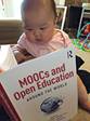 Description: A baby reading a book

Description automatically generated