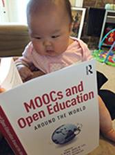 Description: A baby reading a book

Description automatically generated